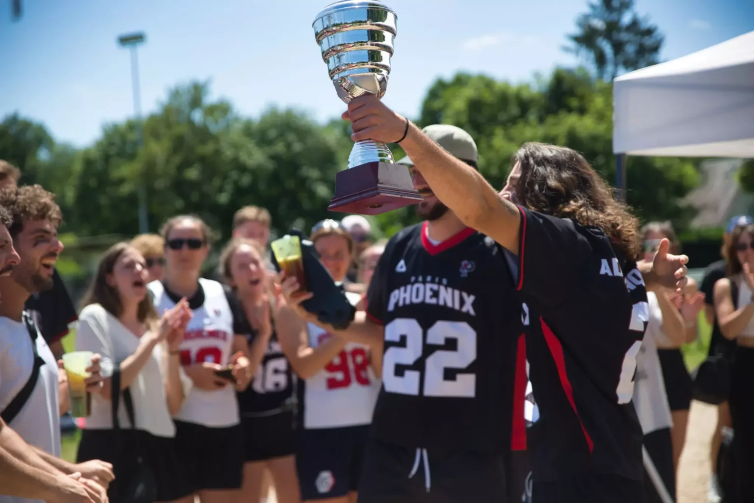 Un joueur du Paris Phoenix soulève le trophée de champions de France devant l’équipe